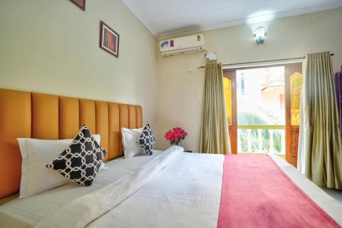 a bedroom with a large bed and a window at Hotel Leela Inn Candolim in Marmagao