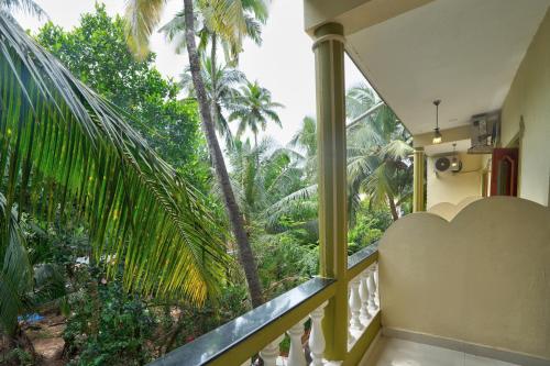 a balcony with a view of the palm trees at Hotel Leela Inn Candolim in Marmagao
