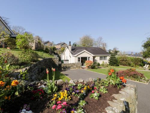 a garden of flowers in front of a house at Clyd Fan in Harlech