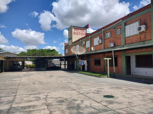 un aparcamiento vacío frente a un edificio de ladrillo en HOTEL BATOVI, en São Gabriel