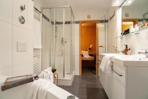 uma casa de banho branca com um chuveiro e 2 lavatórios. em Strandpark-Grossenbrode-Haus-Windrose-Wohnung-13 em Grossenbrode