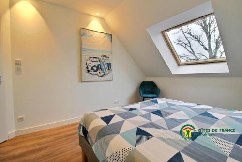 een slaapkamer op zolder met een bed en een raam bij De l'ocean in Le Tour-du-Parc