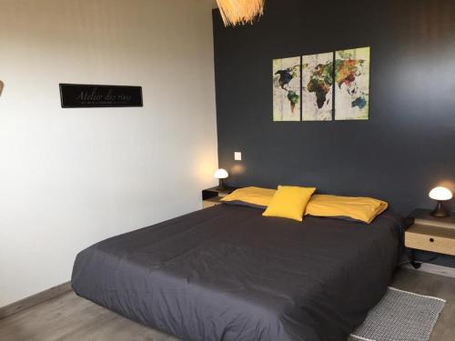 Un dormitorio con una cama grande con almohadas amarillas. en Les flots du bono, en Le Bono