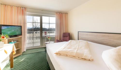 pokój hotelowy z łóżkiem i telewizorem w obiekcie Hotel Sonnenhang w mieście Kempten