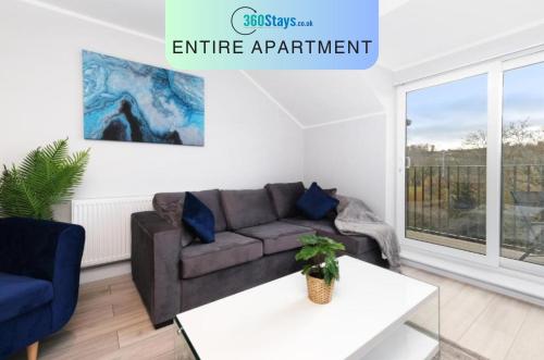 a living room with a couch and a table at The Modern Apartments - 2 Bedroom with Parking by 360Stays in High Wycombe