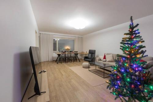 un salon avec un arbre de Noël et une télévision dans l'établissement Huoneisto Rovakatu 27 A7, à Rovaniemi