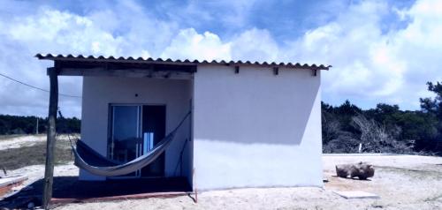 a small white building with a hammock in it at Rinkeby in La Esmeralda 