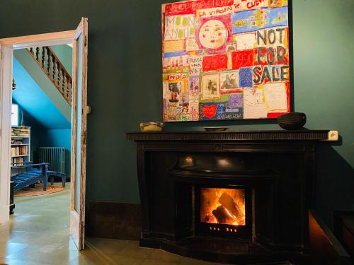 a fireplace in a living room with a painting above it at Carmen Guillemot in Alcanar