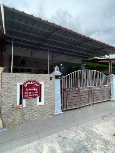 馬六甲的住宿－Homestay ShimahJay Telok Mas Melaka，一座建筑,上面有门和标志