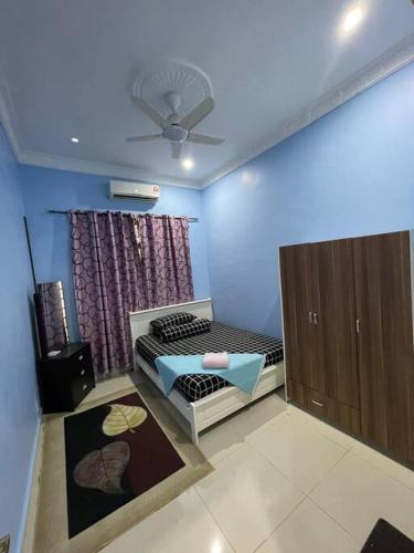 1 dormitorio con 1 cama y ventilador de techo en Homestay ShimahJay Telok Mas Melaka, en Melaka