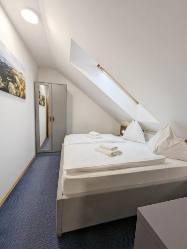 a bedroom with a large white bed in a attic at Penzion Maria in Liptovský Mikuláš