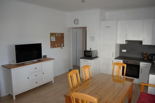 eine Küche mit einem Tisch und Stühlen sowie einem TV in der Unterkunft Apartment Moni in Lutzmannsburg, 1 km von der Sonnentherme entfernt - Apartment mit 3 Schlafzimmern in Lutzmannsburg