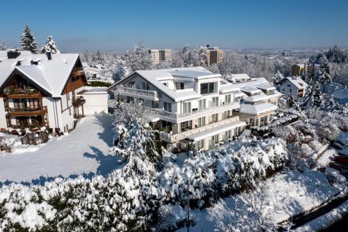 uma vista aérea de uma casa coberta de neve em Hotel Sonnenhang em Kempten