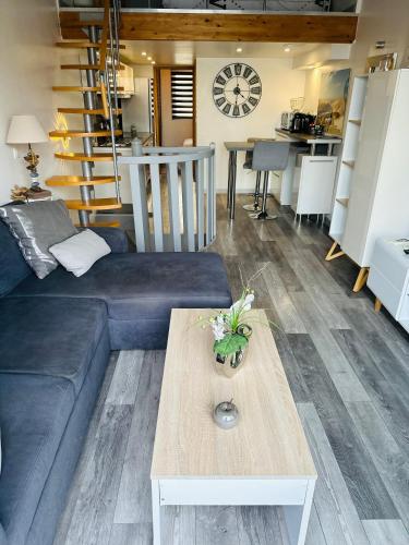 un salon avec un canapé bleu et une table dans l'établissement Duplex sur Marinas Cap d'Agde, au Cap d'Agde