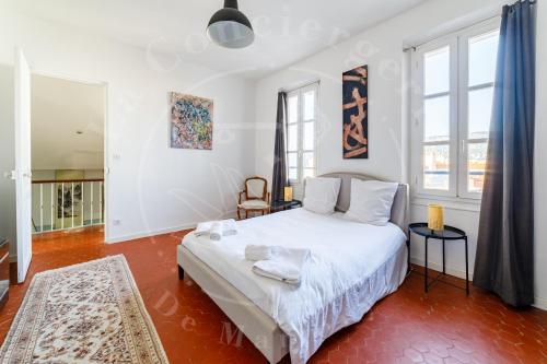 - une chambre avec un grand lit blanc et quelques fenêtres dans l'établissement Une Terrasse au Mourillon, calme et proche Plages, à Toulon