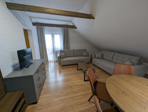 a living room with a couch and a tv and a table at Penzion Maria in Liptovský Mikuláš