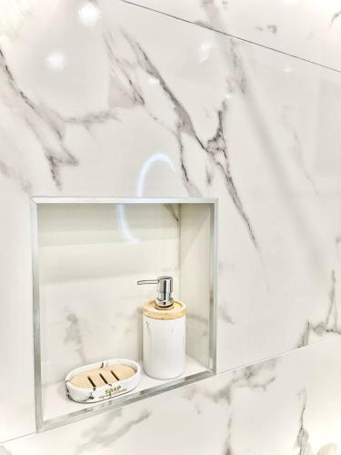 a bathroom with a soap dispenser in a glass box at Perugia Family Flat in Perugia