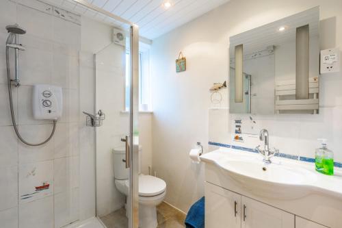 La salle de bains est pourvue d'un lavabo, de toilettes et d'une douche. dans l'établissement 4 Malvern House by Big Skies Cottages, à Trimingham