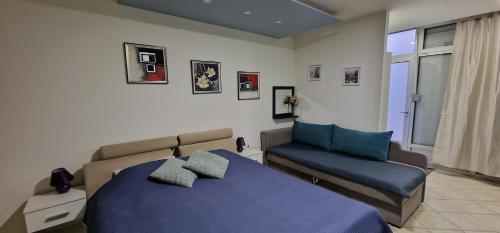 1 dormitorio con 1 cama azul y 1 sofá en Apartman Nives, en Prijedor