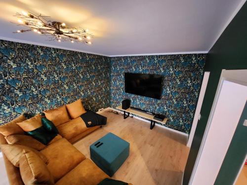 a living room with a couch and a tv at Inspiring Apartment near city center in Mikkeli