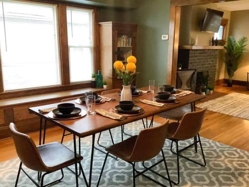 stół jadalny z krzesłami i kwiatami w obiekcie The House Hotels - Cohasset upper w mieście Lakewood