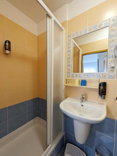 a bathroom with a sink and a shower at Penzion Maria in Liptovský Mikuláš
