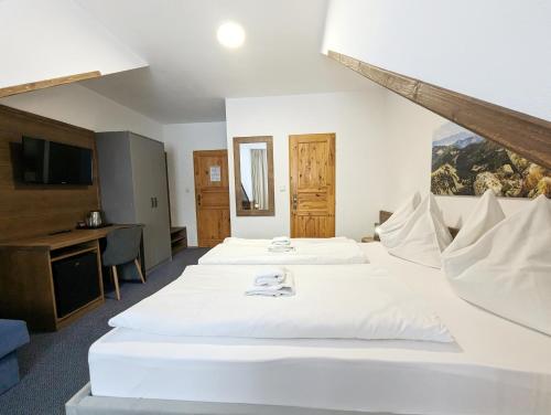 a hotel room with two beds and a desk at Penzion Maria in Liptovský Mikuláš