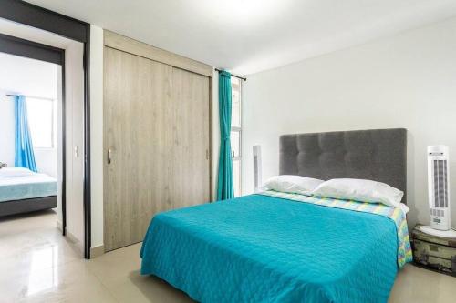 a bedroom with a bed with a blue blanket at Apartment Medellinsabaneta near metro station in Sabaneta