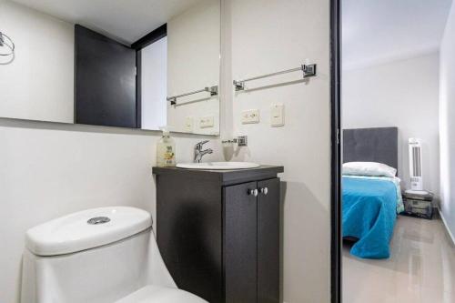 a bathroom with a toilet and a sink and a bed at Apartment Medellinsabaneta near metro station in Sabaneta