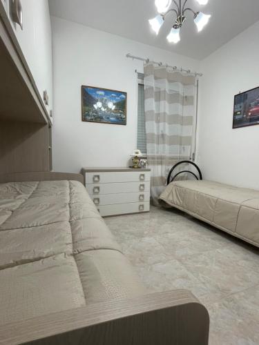 Un dormitorio con dos camas y una cómoda. en Dimora Carmela, en Torre Santa Sabina