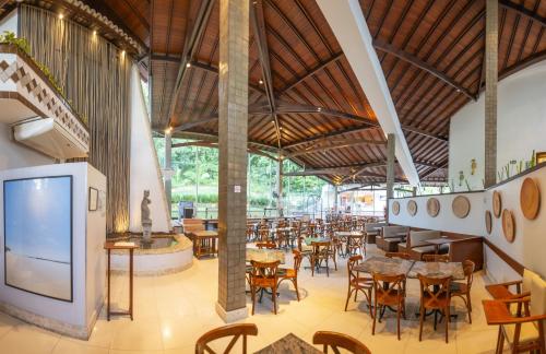 a restaurant with tables and chairs and a tv at Best Western Shalimar Praia Hotel in Porto Seguro
