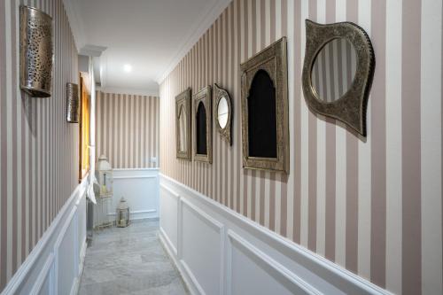een hal met gestreepte muren en spiegels aan de muur bij Reina Aixa- Apartamento Centro in Granada