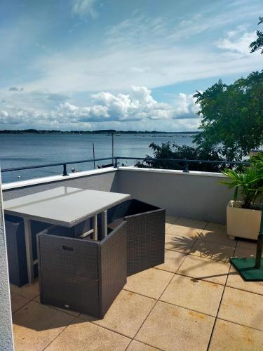 a patio with a table and a view of the ocean at Location les pieds dans l'eau in Vannes