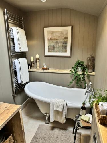 a bathroom with a white tub in a room at Appleby Barn in Lacock