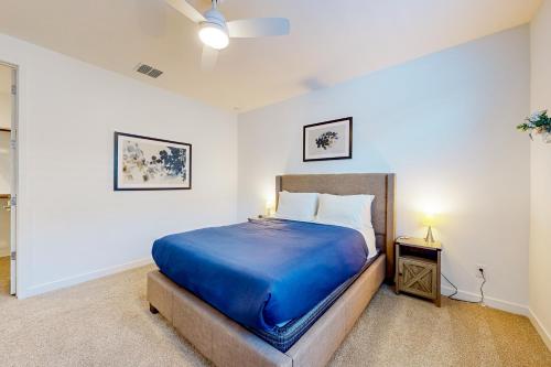 a bedroom with a large bed with a blue blanket at Phoenix Star - Main House & Casita in Phoenix