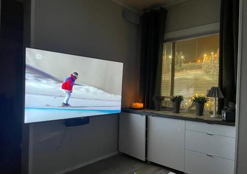 a tv with a person skiing on a screen at VuosselinHelmi 44 in Kuusamo