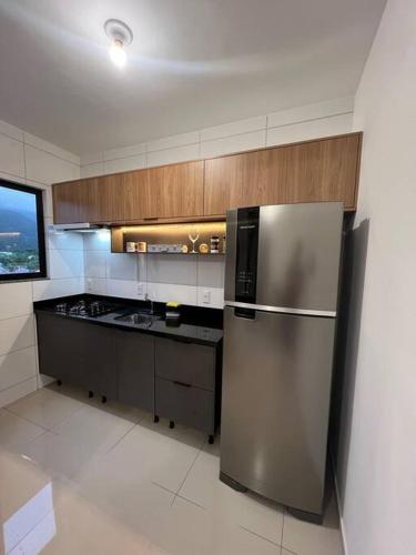 a kitchen with a stainless steel refrigerator and a stove at Apartamento praia de fora in Palhoça