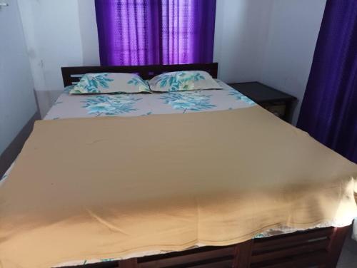 1 dormitorio con 1 cama con cortinas azules en Munnar Hills & Mist View en Anachal