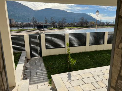 a building with a fence and a body of water at Vila Petra in Trebinje