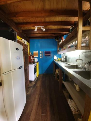 cocina con nevera blanca y paredes azules en Casa Encantada Guest House, en La Aguada