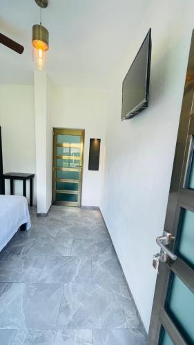 Zimmer mit einem TV an der Wand und einem Bett in der Unterkunft Rancho Los Quiñones in Leona Vicario