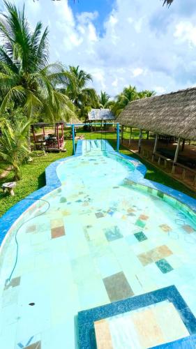 einen Pool im Resort mit Palmen im Hintergrund in der Unterkunft Rancho Los Quiñones in Leona Vicario