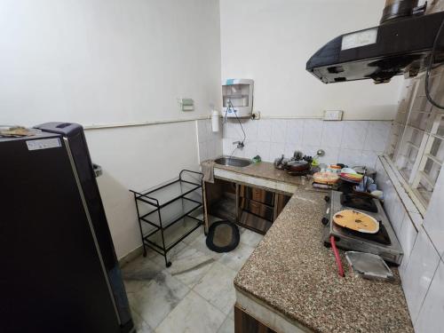 una pequeña cocina con encimera y nevera en Shaan ppartment, en Guwahati