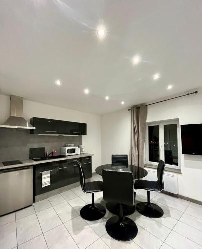 une cuisine avec une table et des chaises dans une pièce dans l'établissement Duchesse de Berry - Vue sur port, à Dieppe