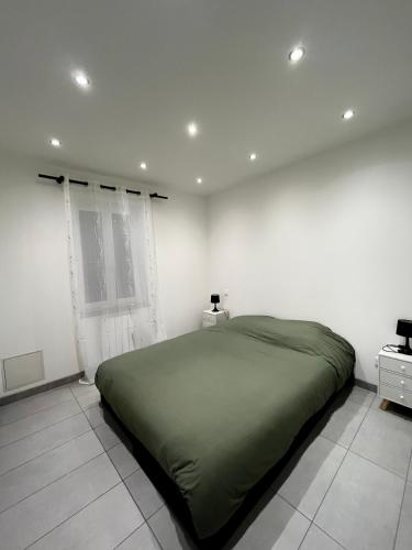 a bedroom with a green bed in a white room at Duchesse de Berry - Vue sur port in Dieppe