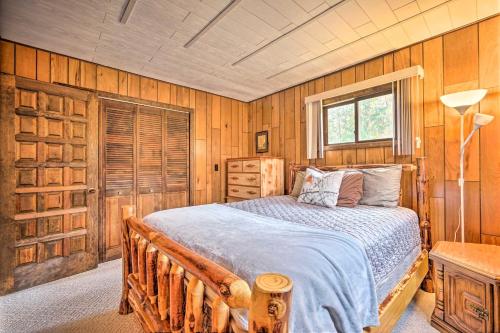 a bedroom with a bed in a room with wooden walls at Fresh and Retro Chalet Fire Pit, 4 Min to Gore Mtn in North Creek