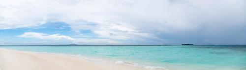 a beach with the ocean and blue water at Biosphere Inn in Dharavandhoo