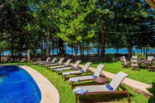 una fila de tumbonas junto a una piscina en Blue Jewel Oceanfront Private Villa, en Tamarindo