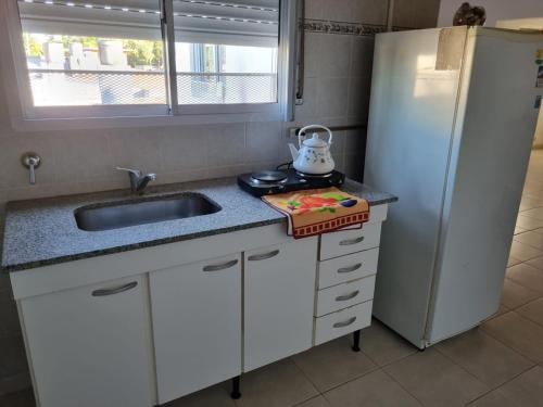 a kitchen with a sink and a refrigerator at Monoambiente Gualeguaychú in Gualeguaychú