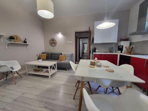 a kitchen and living room with white tables and chairs at Oasis Home-Garden Gem in The Heart of Bucharest in Bucharest